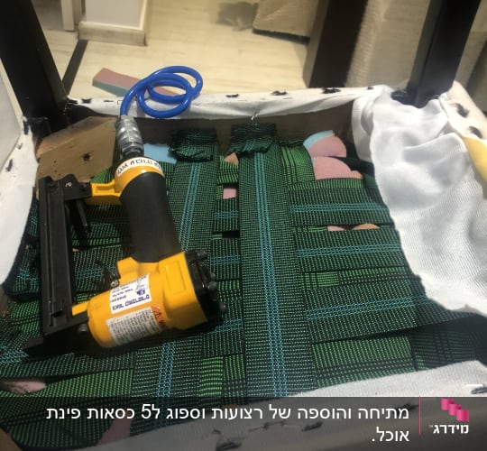 אקדח סיכות על רצועות ירוקות בכיסא מרופד